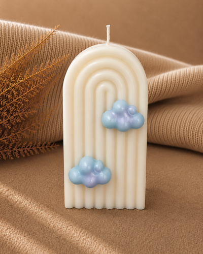 Vela decorativa en forma de arociris con nubes azules con fondo neutro
