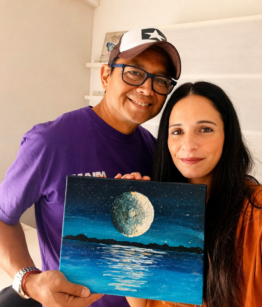 Foto de los fundadores de la marca sosteniendo un cuadro de mar y luna que representa la marca y nuestra historia