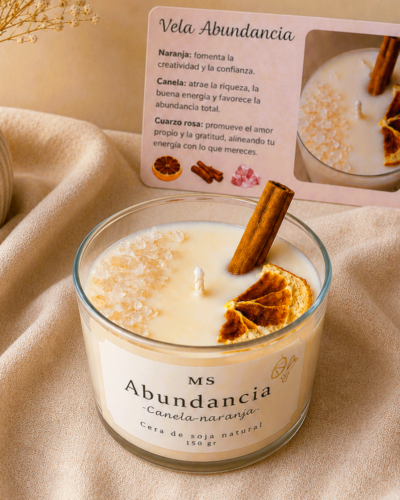 vela intencionada de abundancia con aroma a canela y naranja sobre fondo cálido