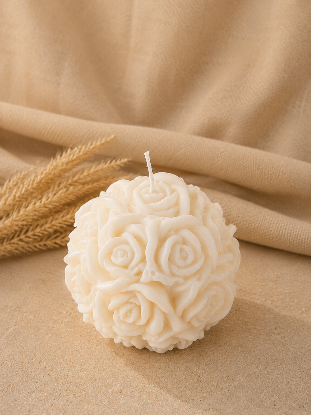 Vela decorativa en forma de rosas con fondo neutro