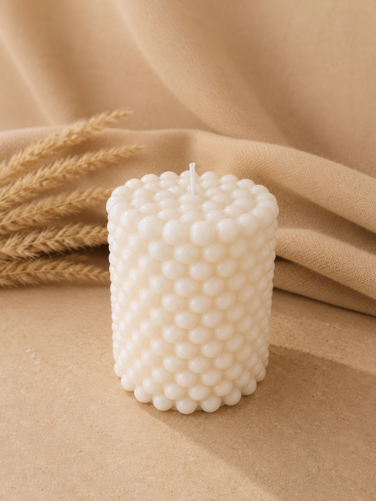 Vela decorativa en forma de pequeñas perlas con fondo neutro
