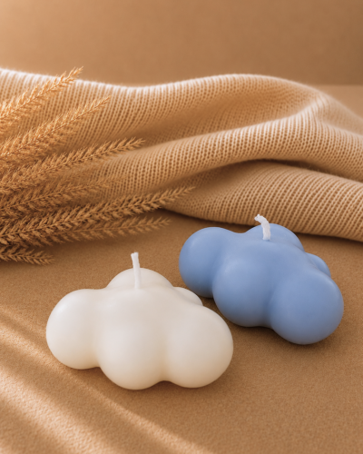 Velas decorativas en forma de nuebes clanca y azul con fondo neutro