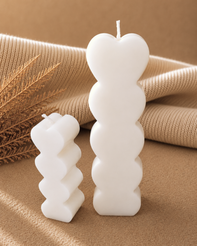 vela decorativa en forma de columna de corazones con fondo neutro