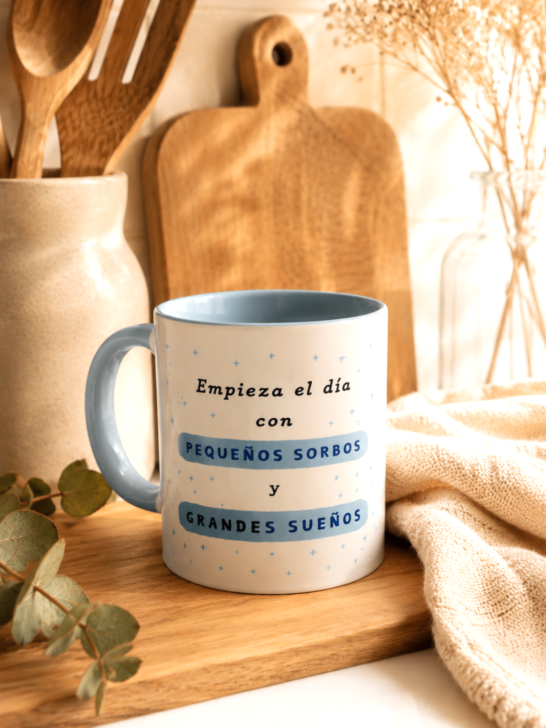Taza personalizada con frase inspiradora en color blanco y celeste con fondo de cocina de madera